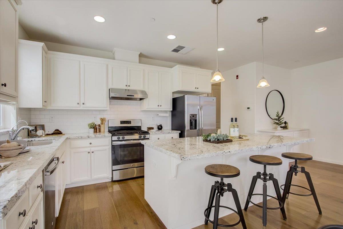 4132 Panorama Drive Dublin, CA 94568 - Photo 16 of 53 a kitchen with stainless steel appliances granite countertop a sink a stove a refrigerator and chairs