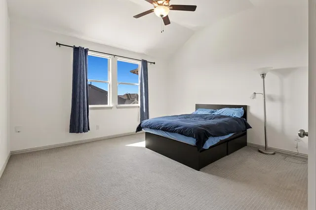 a spacious bedroom with a bed and a ceiling fan