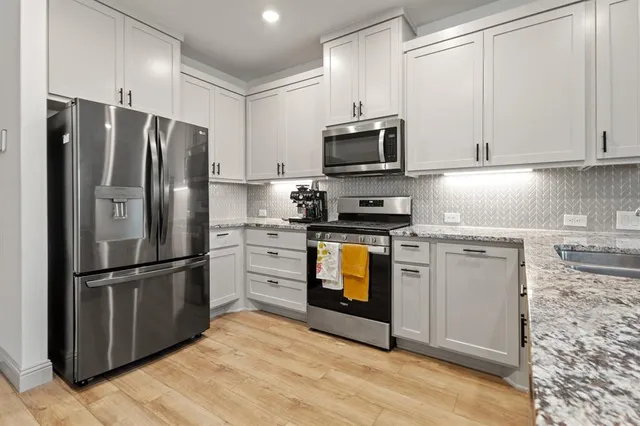 a kitchen with stainless steel appliances a refrigerator stove and microwave