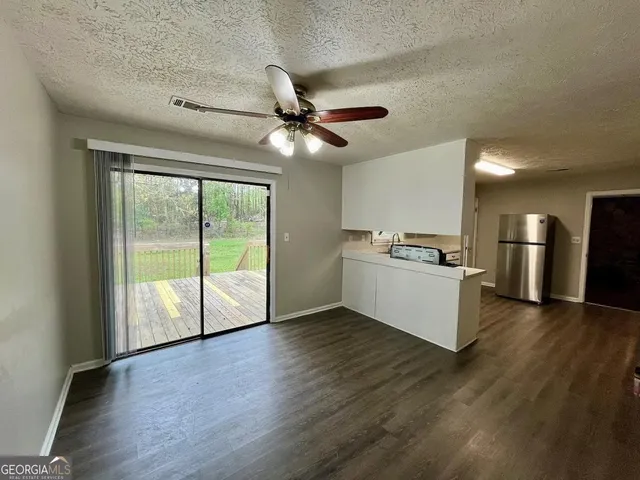 a view of kitchen with stainless steel appliances wooden floor and a large window