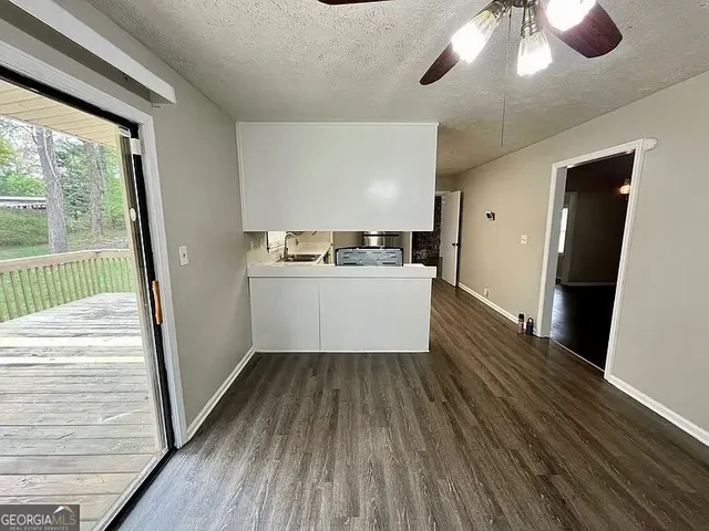 a view of a kitchen with wooden floor a sink and windows