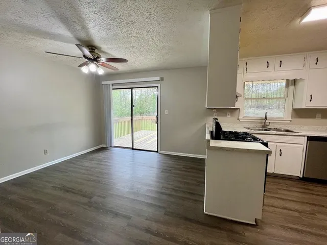 a kitchen with granite countertop a stove cabinets and wooden floor