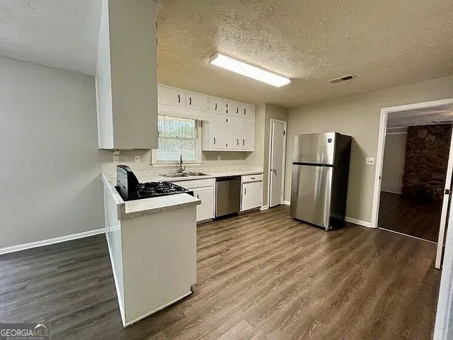 a kitchen with stainless steel appliances a refrigerator and a stove top oven