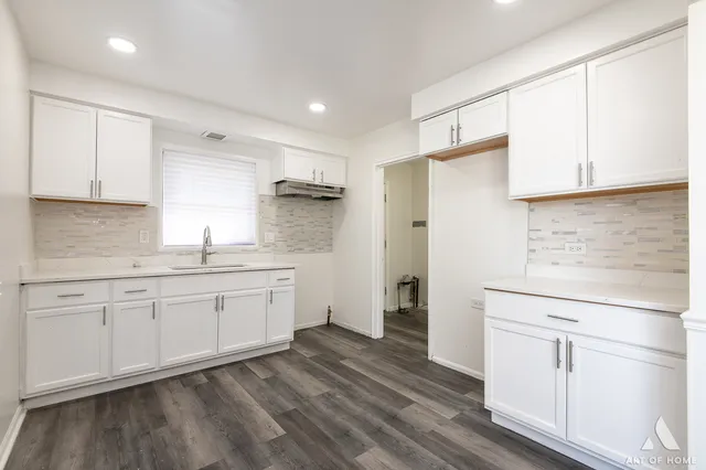 a kitchen with granite countertop white cabinets and white appliances