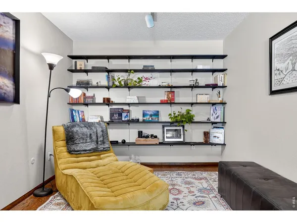 a bedroom with a bed a window and shelf