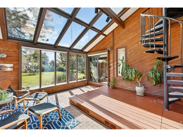 a living room with patio furniture and floor to ceiling windows