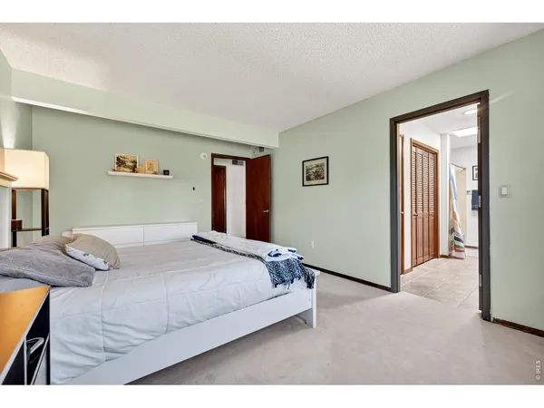 a bedroom with a bed and a painting on the wall