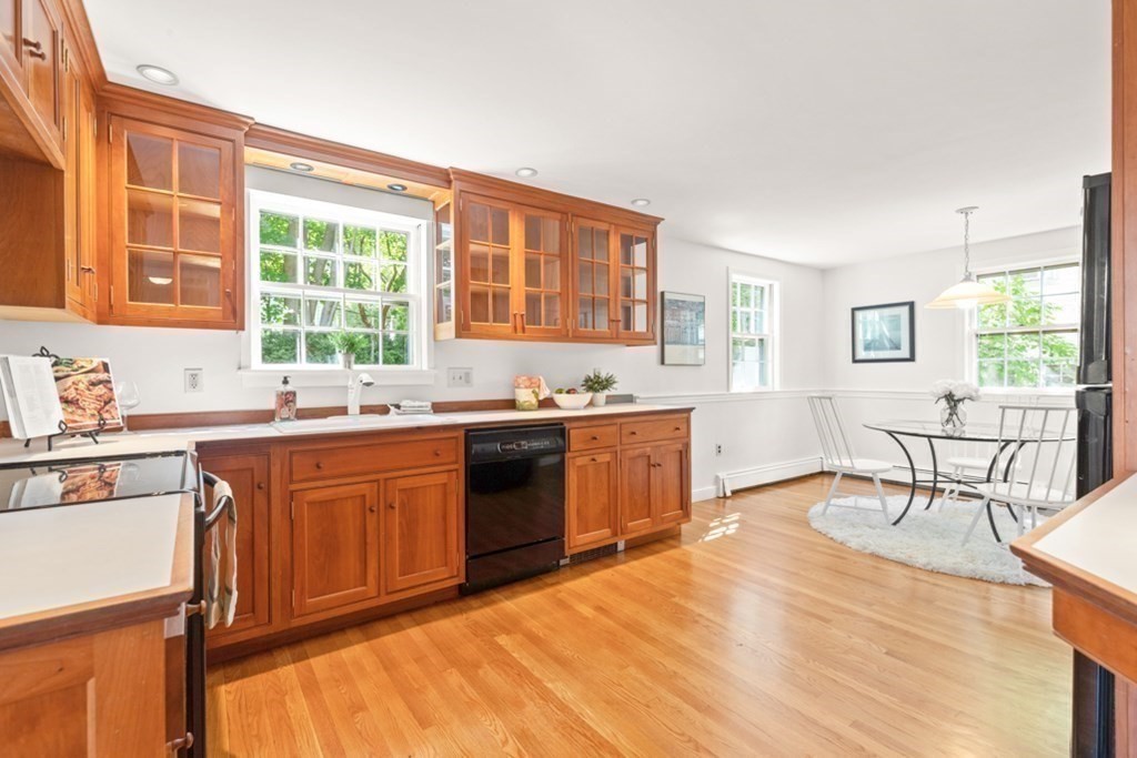 68 School Street Lexington, MA 02421 - Photo 9 of 24 a large kitchen with granite countertop a stove a sink and a dining table view with wooden floor