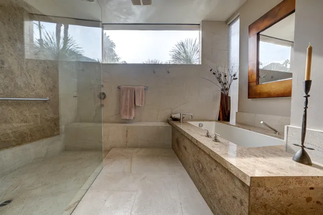 a bathroom with a granite countertop bathtub sink vanity and mirror