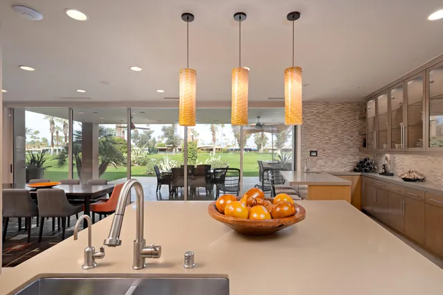a kitchen with stainless steel appliances wooden floor and a large window