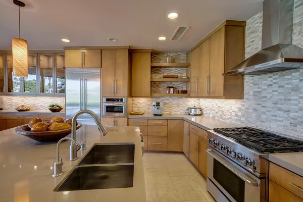 a kitchen with stainless steel appliances a stove a sink and a refrigerator