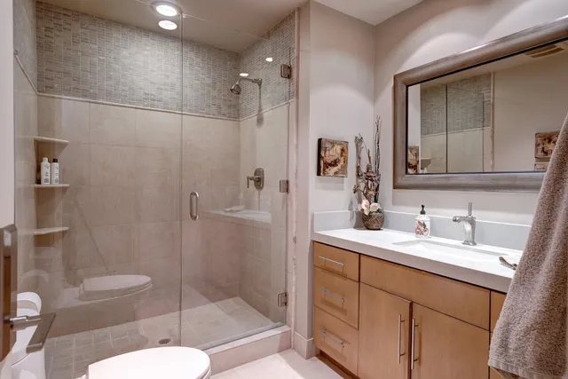 a bathroom with a sink a toilet and shower