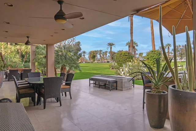 a view of a patio with a table chairs and a backyard