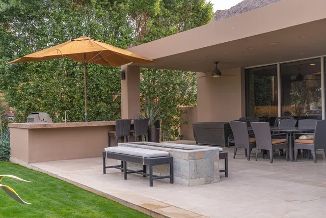 a view of a patio with table and chairs under an umbrella