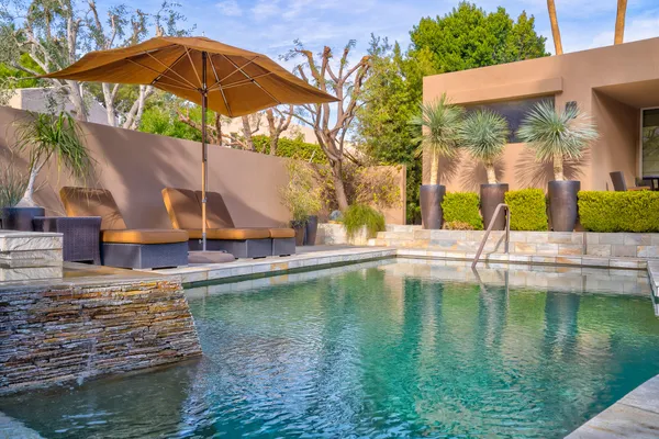 a view of a swimming pool with a bench in patio