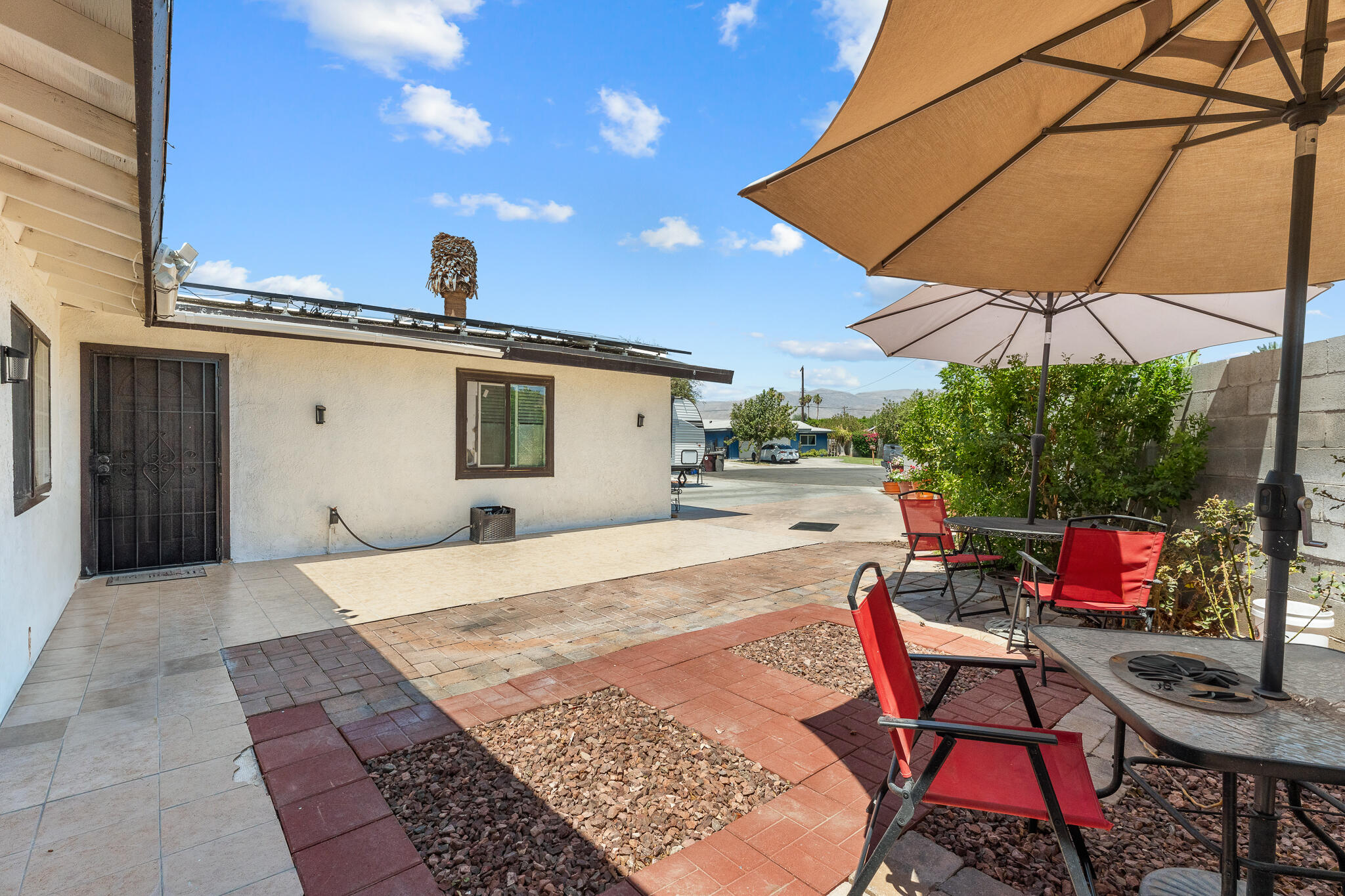83307 Tourmaline Avenue Indio, CA 92201 - Photo 3 of 38 a patio with a table and chairs under an umbrella