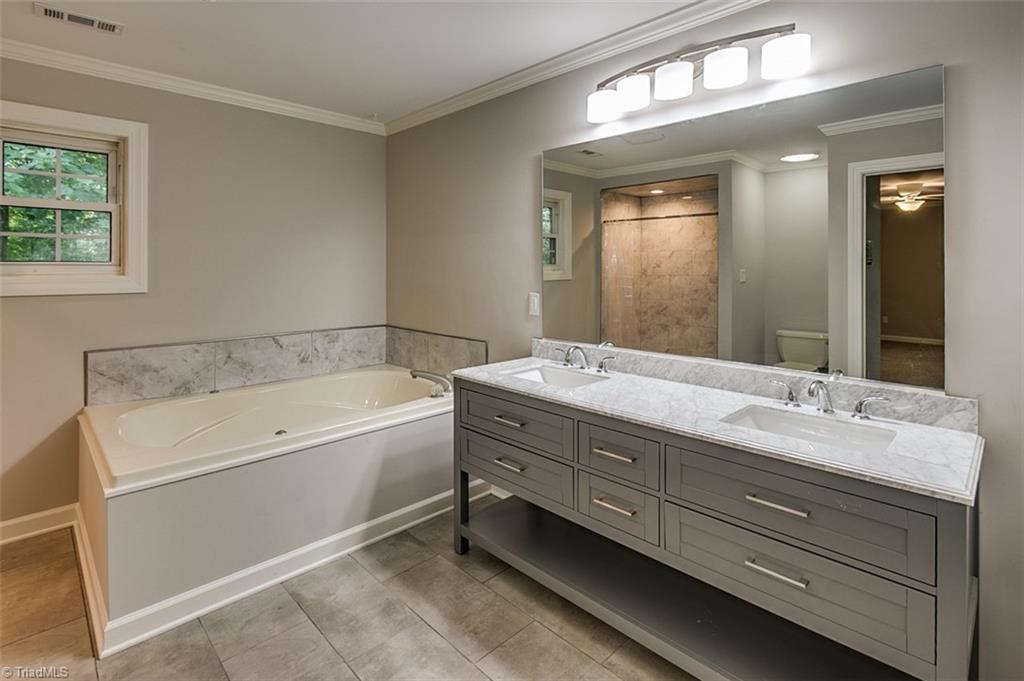 2601 Kilpatrick White Road Greensboro, NC 27406 - Photo 12 of 30 Master suite bath has a jetted tub, double vanity with storage, and a fully tiled separate shower, large enough for two.