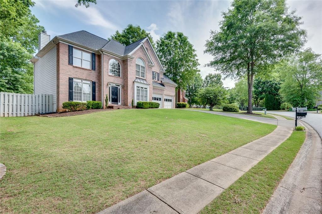 2439 Ryan Leigh Ridge Northwest Duluth, GA 30096 - Photo 1 of 1 a view of a house next to a big yard and large trees