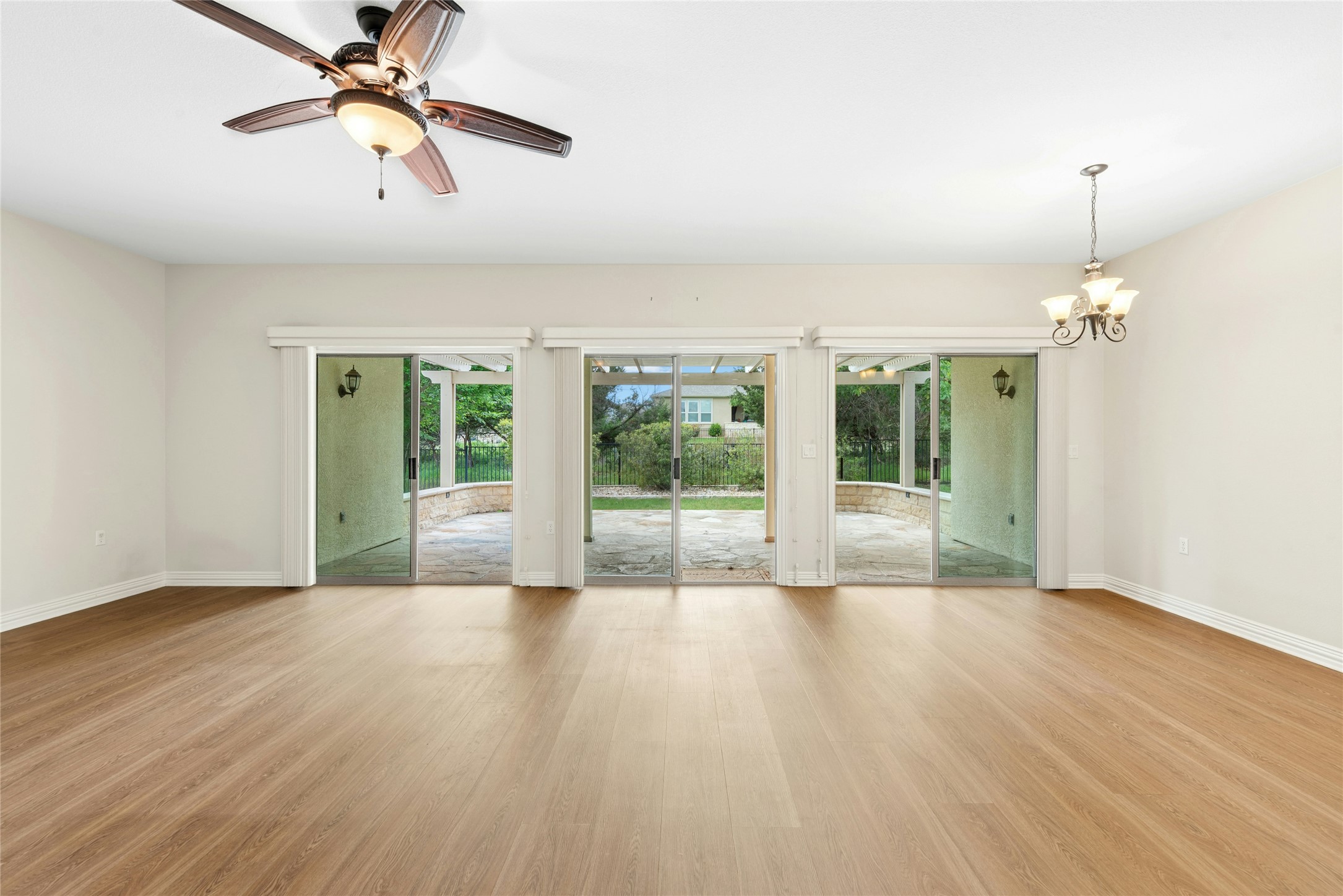 227 Duck Creek Lane Georgetown, TX 78633 - Photo 12 of 40 a view of a livingroom with wooden floor a ceiling fan and windows