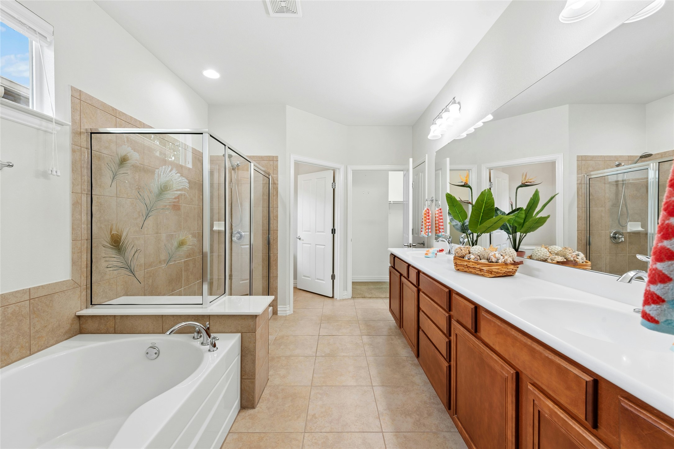 227 Duck Creek Lane Georgetown, TX 78633 - Photo 18 of 40 a spacious bathroom with a double vanity sink a large mirror a bathtub and next to a window