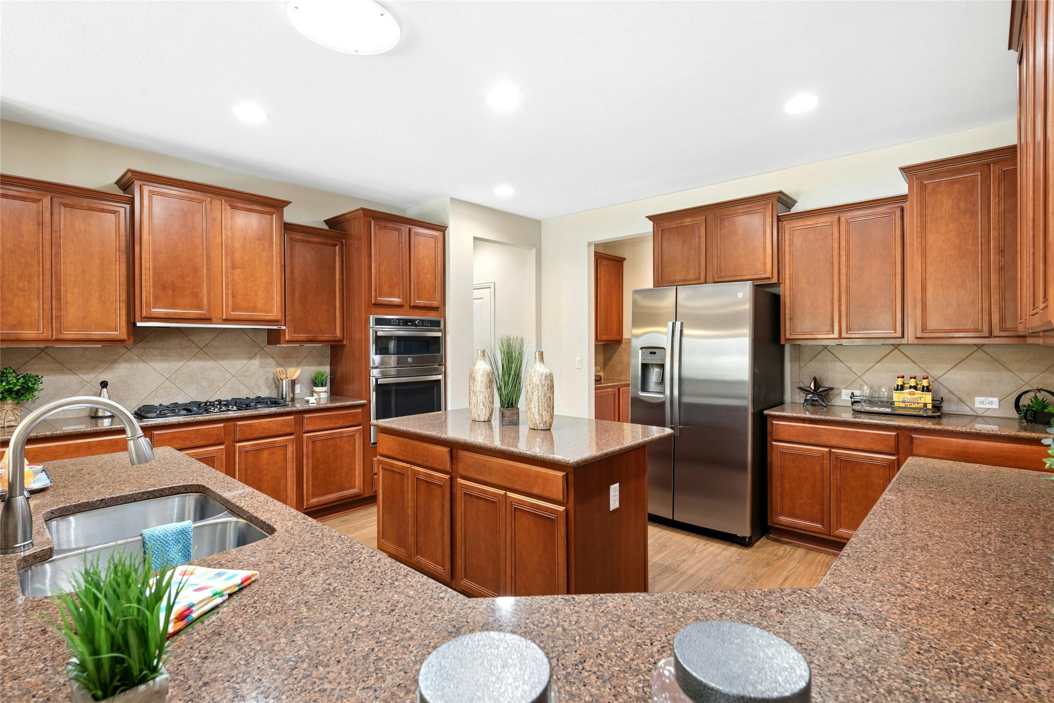 227 Duck Creek Lane Georgetown, TX 78633 - Photo 9 of 40 a kitchen with stainless steel appliances granite countertop a refrigerator a sink dishwasher a stove with wooden cabinets and floor
