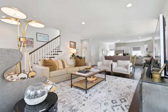 a living room with furniture and view of kitchen