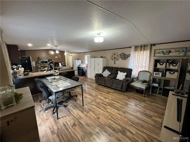 a living room with lots of furniture and view of kitchen