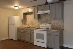a kitchen with stainless steel appliances granite countertop a stove a refrigerator and a wooden cabinets