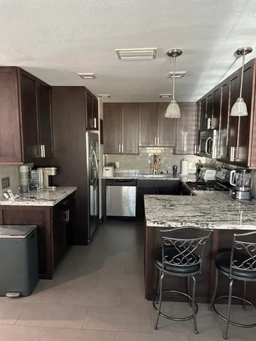 a kitchen with stainless steel appliances granite countertop a sink stove and refrigerator