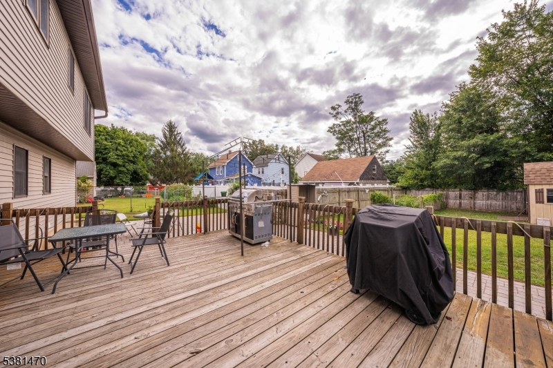 1 Hall Street Piscataway, NJ 08854 - Photo 18 of 21 a view of a roof deck with table and chairs a barbeque with wooden floor and fence