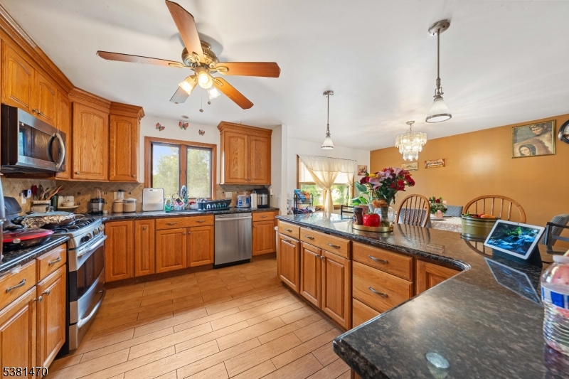 1 Hall Street Piscataway, NJ 08854 - Photo 7 of 21 a kitchen with stainless steel appliances granite countertop a sink dishwasher stove and wooden cabinets