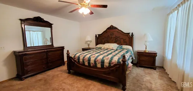 a bedroom with a bed and a mirror on the dresser