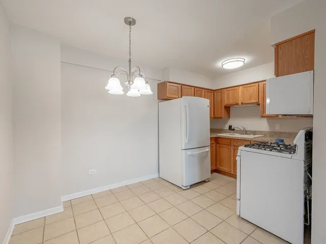 a kitchen with refrigerator and white cabinets