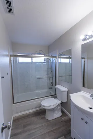 a bathroom with a sink a toilet and shower