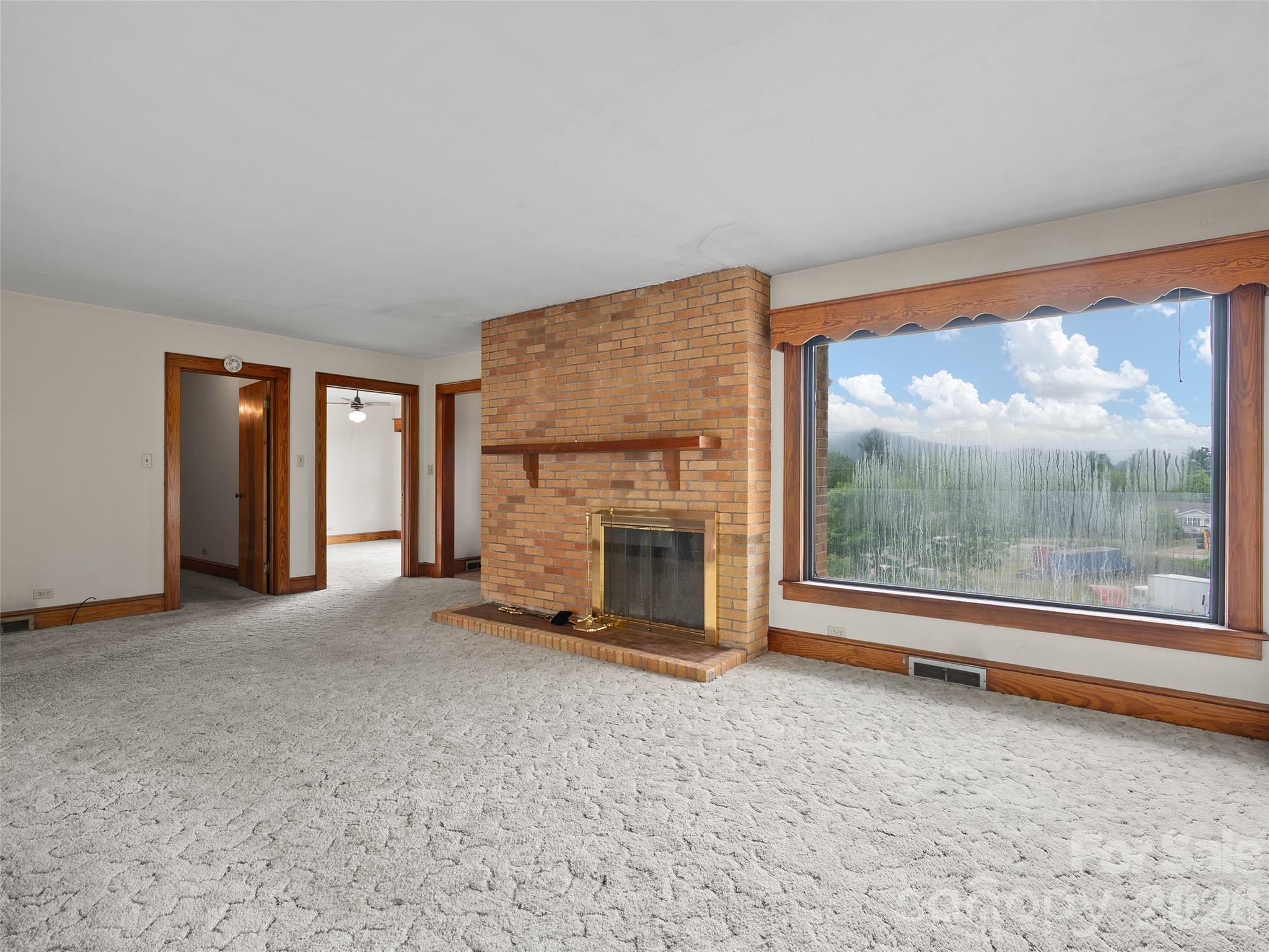 21 Beaverdam Road Canton, NC 28716 - Photo 7 of 24 an empty room with floor to ceiling windows and fireplace