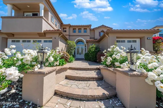 a front view of a house with a yard and a garden