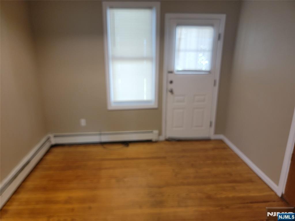 165 Corabelle Avenue, Unit 2 Lodi, NJ 07644 - Photo 5 of 7 an empty room with a empty space and windows
