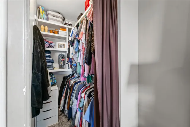 a view of walk in closet with clothes