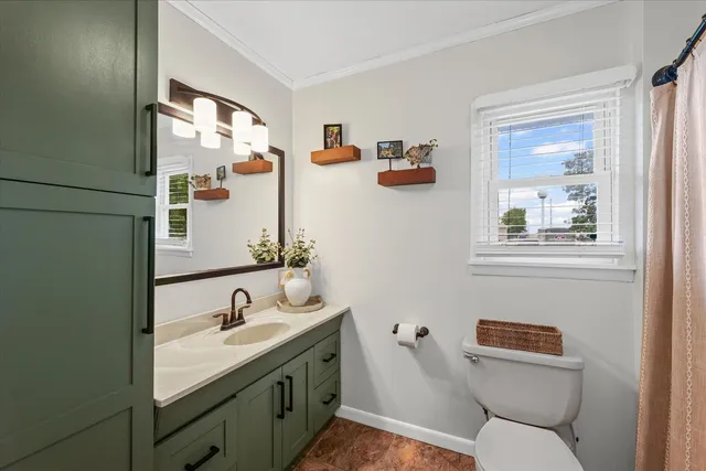 a bedroom with a bed a window and flat screen tv