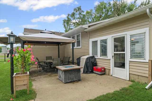 a view of a house with a yard patio and tree