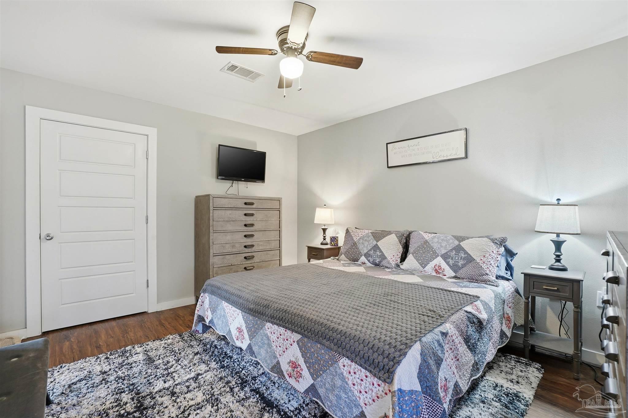 402 Front Street Century, FL 32535 - Photo 22 of 48 a bedroom with a bed a dresser and a chandelier
