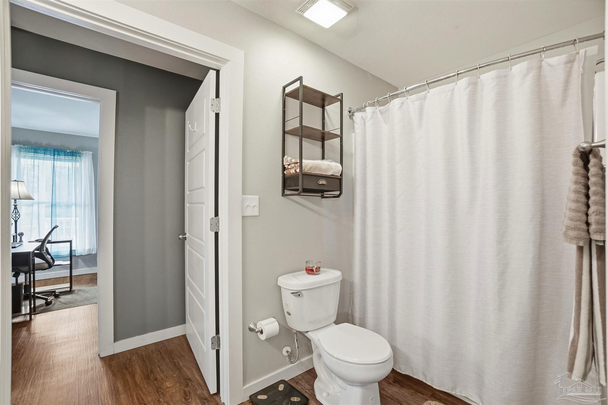 402 Front Street Century, FL 32535 - Photo 24 of 48 a bathroom with a toilet and a shower curtain