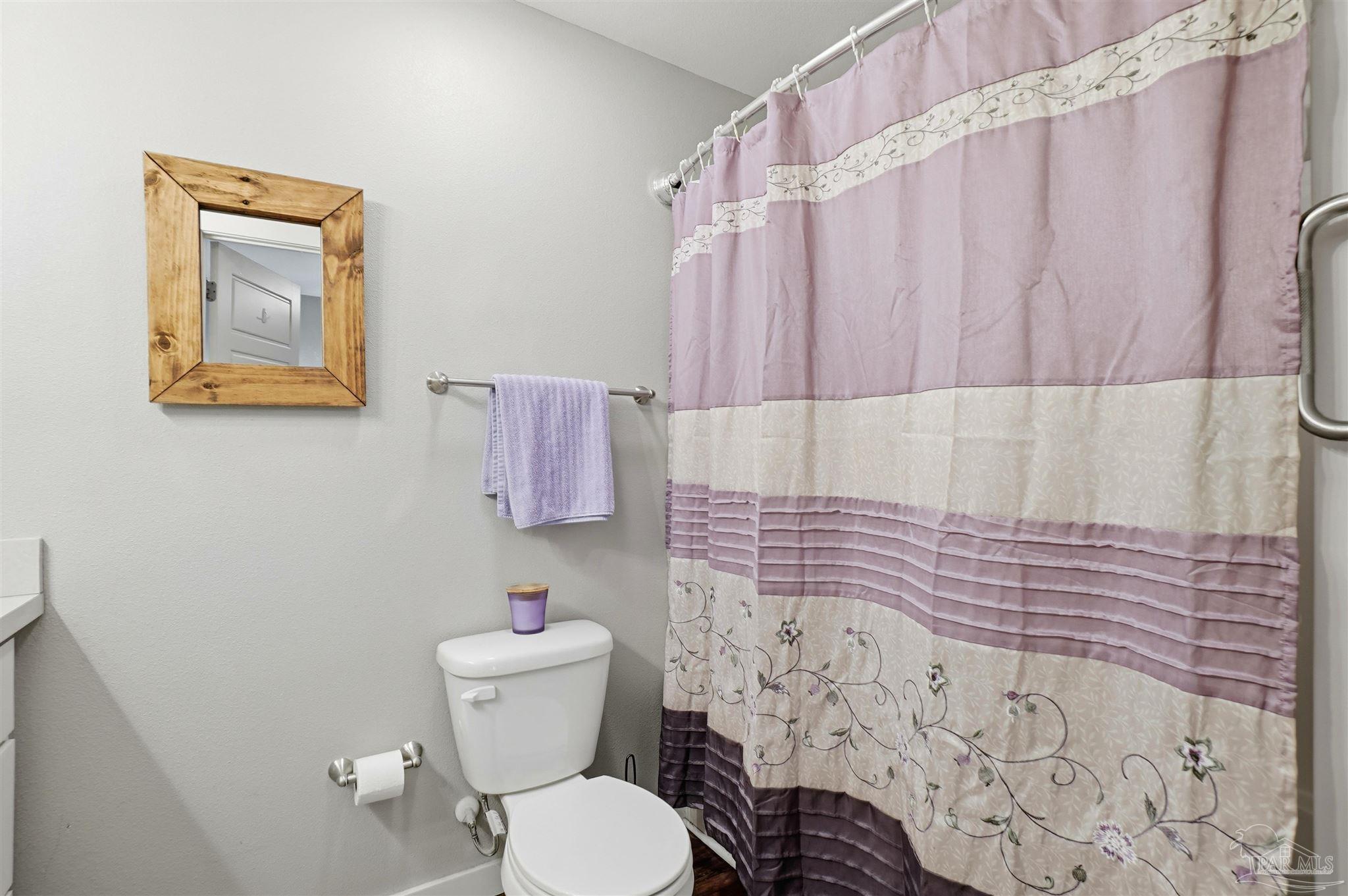 402 Front Street Century, FL 32535 - Photo 26 of 48 a bathroom with a toilet and a shower curtain