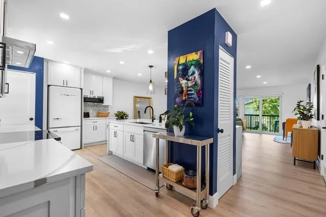 a kitchen with white cabinets and refrigerator