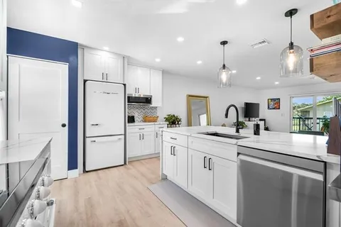 a kitchen with white cabinets and white appliances