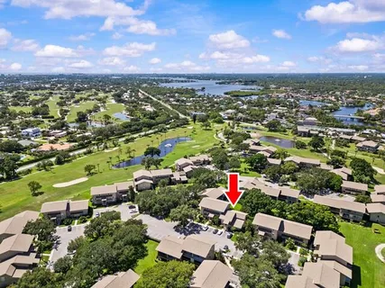 an aerial view of residential houses with outdoor space and trees