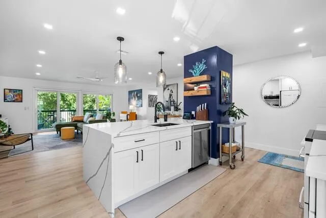 a large white kitchen with lots of counter space and chandelier