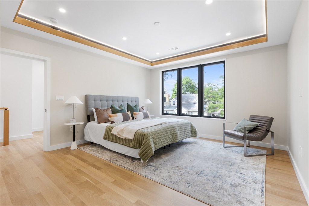 22 Appleton Street, Unit 1 Waltham, MA 02453 - Photo 16 of 36 a bed sitting in a spacious bedroom next to a window