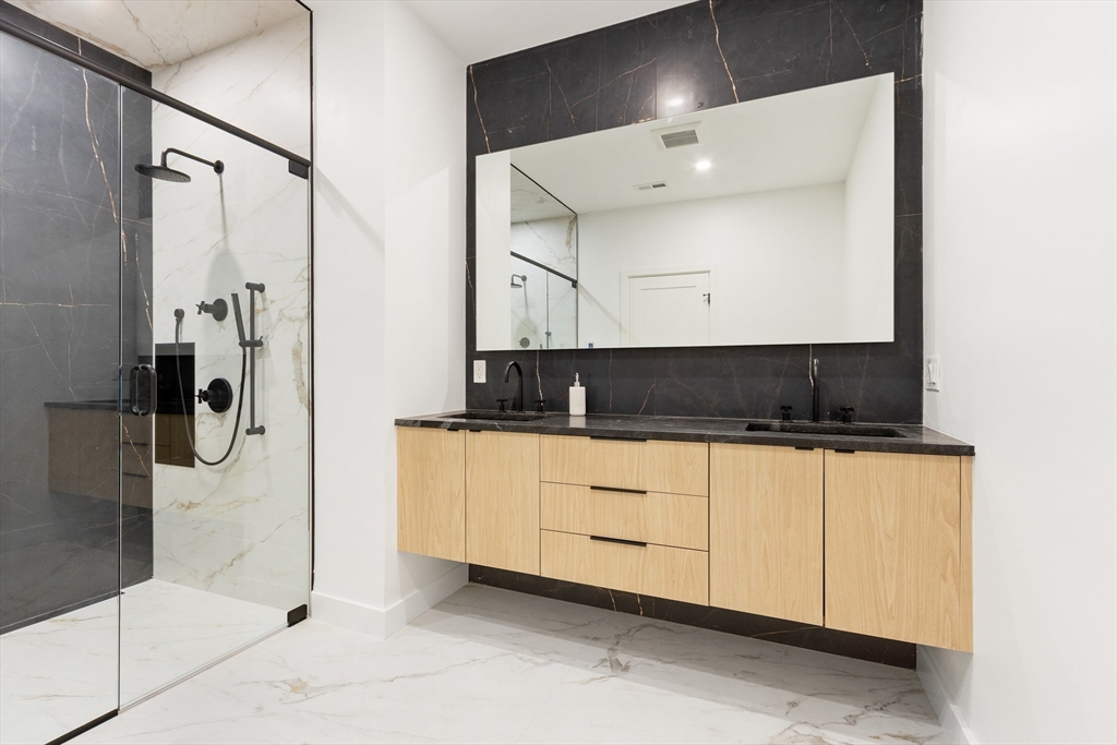 22 Appleton Street, Unit 1 Waltham, MA 02453 - Photo 19 of 36 a bathroom with a double vanity sink a mirror and a shower