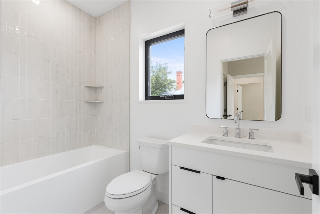 22 Appleton Street, Unit 1 Waltham, MA 02453 - Photo 26 of 36 a bathroom with a toilet a sink a mirror a bathtub and vanity
